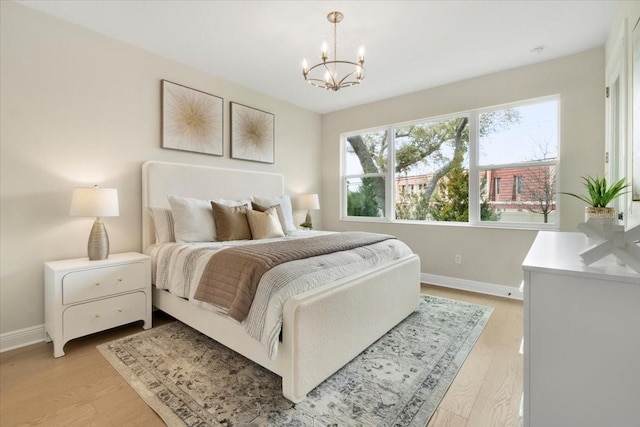 bedroom with a chandelier and light hardwood / wood-style flooring