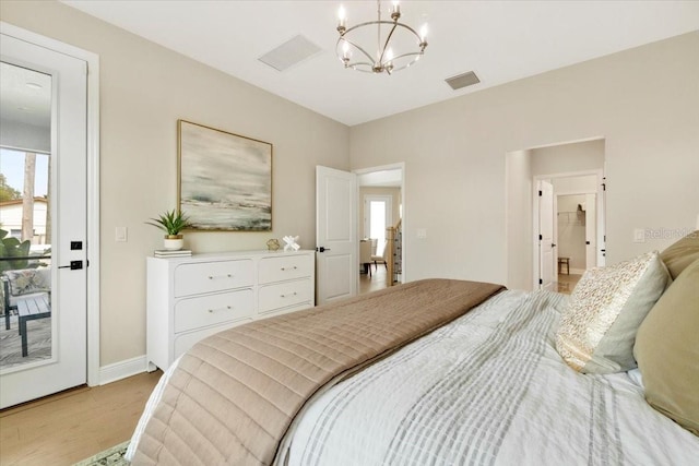 bedroom with a notable chandelier, light wood-type flooring, and access to outside