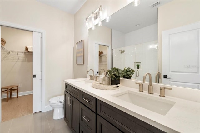 bathroom featuring tile patterned flooring, vanity, an enclosed shower, and toilet