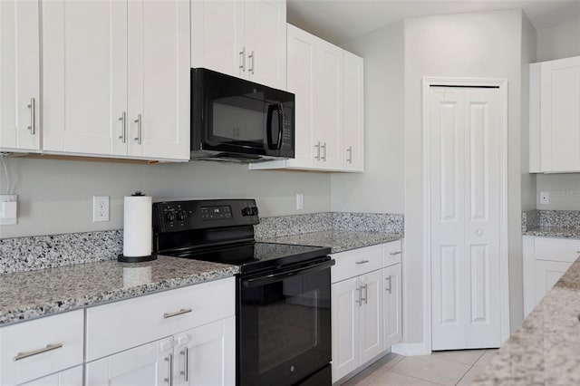 kitchen featuring light tile patterned flooring, light stone countertops, white cabinets, and black appliances