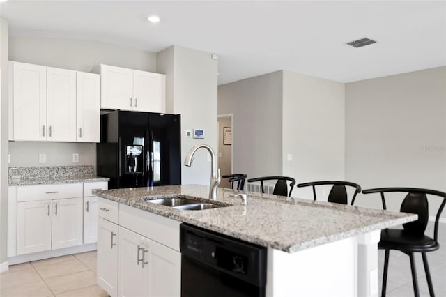 kitchen with black appliances, white cabinets, a center island with sink, and sink