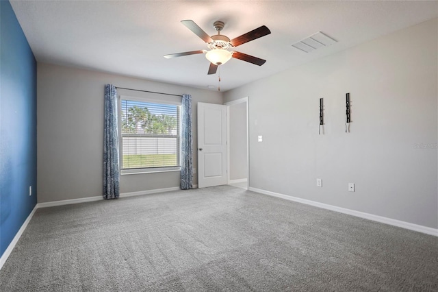 carpeted spare room featuring ceiling fan