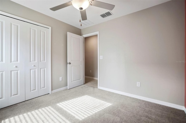 unfurnished bedroom with ceiling fan, a closet, and light colored carpet