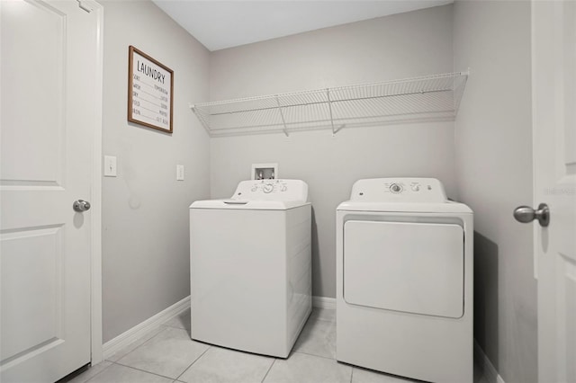 laundry room with washer and dryer and light tile patterned floors