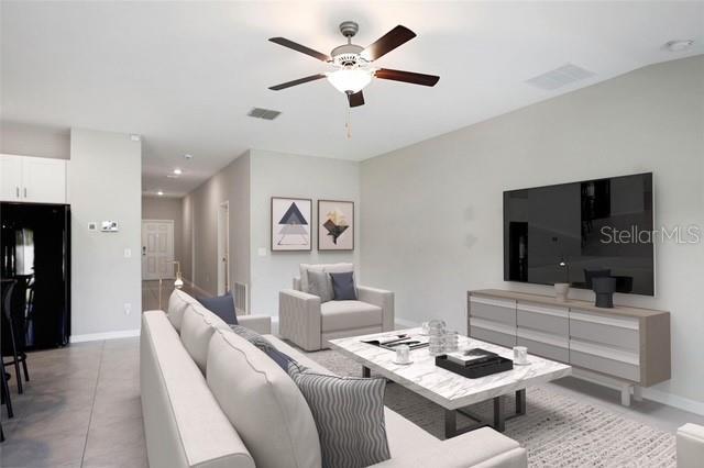 living area with a ceiling fan, visible vents, and baseboards