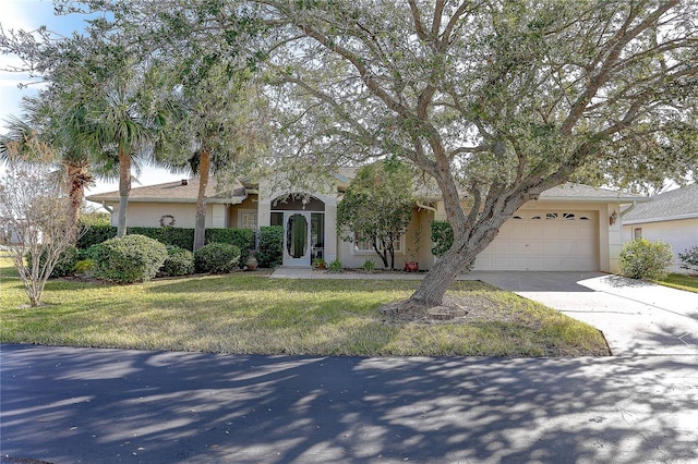 obstructed view of property featuring a garage and a front lawn