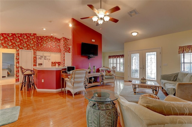 living room featuring french doors, light hardwood / wood-style flooring, ceiling fan, and lofted ceiling