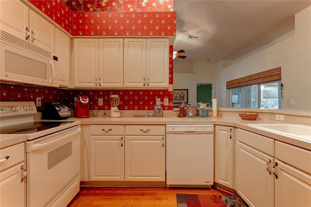 kitchen with light hardwood / wood-style floors, white appliances, and kitchen peninsula