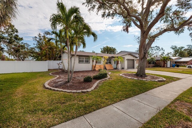 ranch-style house with a garage and a front lawn