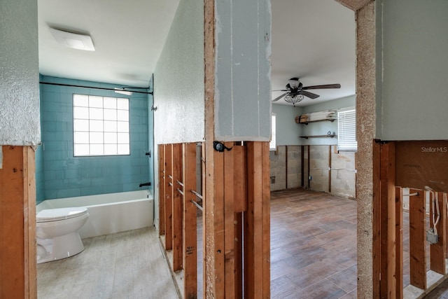 bathroom with a wealth of natural light, toilet, and ceiling fan