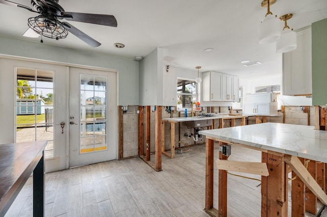 kitchen featuring french doors, white cabinetry, ceiling fan, and a healthy amount of sunlight