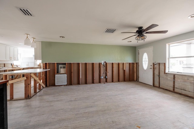 kitchen with light hardwood / wood-style flooring, white cabinetry, and ceiling fan