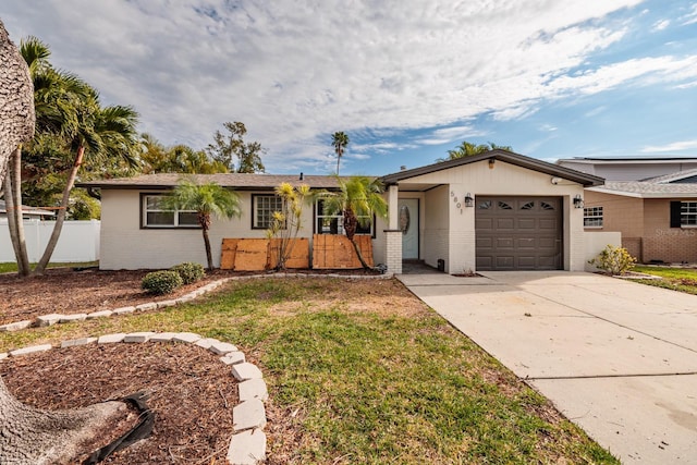 ranch-style home featuring a garage and a front lawn