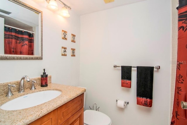 bathroom with a shower with curtain, vanity, and toilet