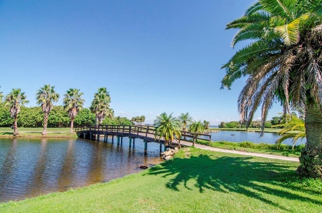 view of dock featuring a lawn and a water view