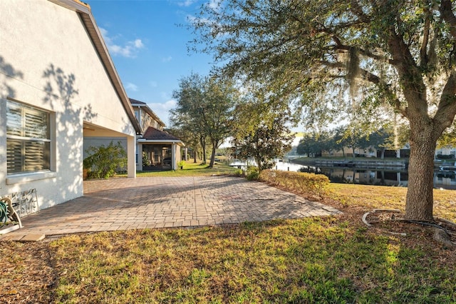 view of yard featuring a patio and a water view