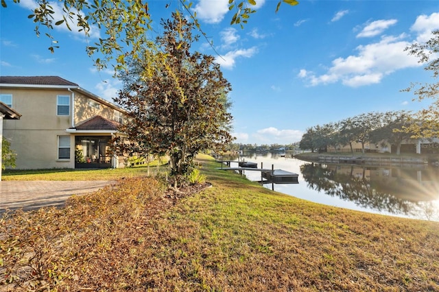 view of yard featuring a dock and a water view