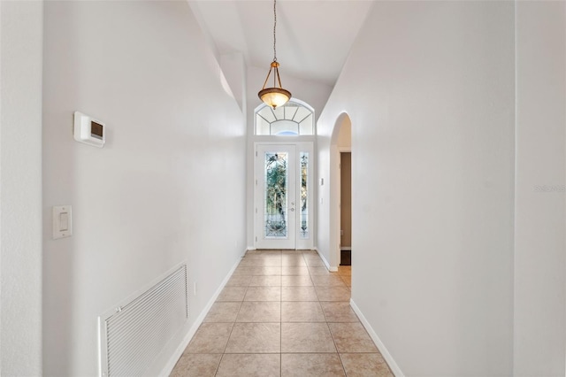 tiled foyer entrance featuring high vaulted ceiling