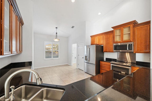 kitchen featuring lofted ceiling, hanging light fixtures, sink, light tile patterned floors, and appliances with stainless steel finishes