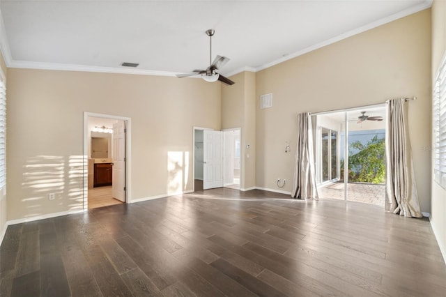 interior space with a towering ceiling, dark hardwood / wood-style floors, ceiling fan, and ornamental molding