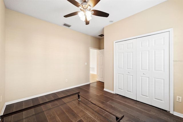 unfurnished bedroom featuring ceiling fan, a closet, and dark hardwood / wood-style floors