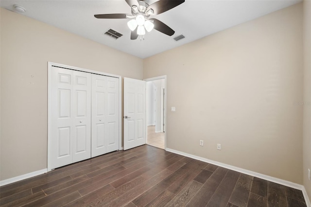 unfurnished bedroom with ceiling fan, dark hardwood / wood-style floors, and a closet