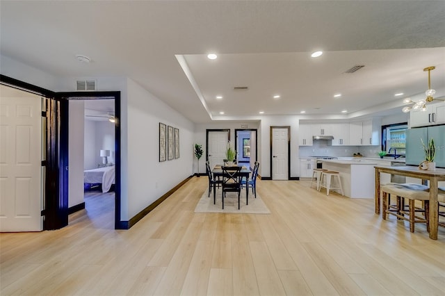 dining room featuring light hardwood / wood-style floors, ceiling fan, and sink