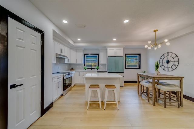 kitchen featuring a center island, backsplash, an inviting chandelier, white cabinets, and stainless steel appliances