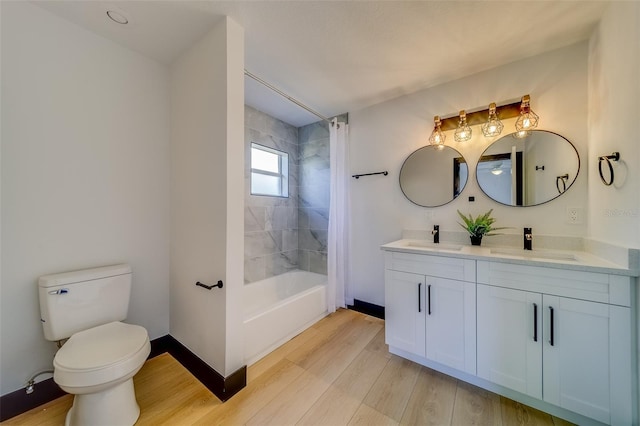 full bathroom featuring hardwood / wood-style flooring, vanity, toilet, and shower / bath combo with shower curtain