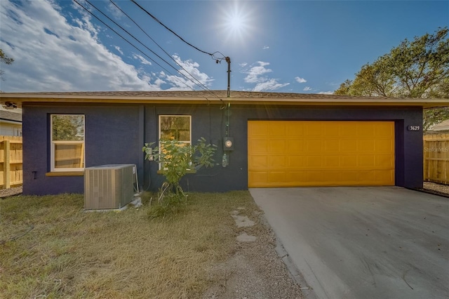 ranch-style home with cooling unit and a garage