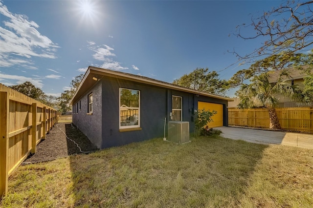 rear view of house with a yard and central AC unit