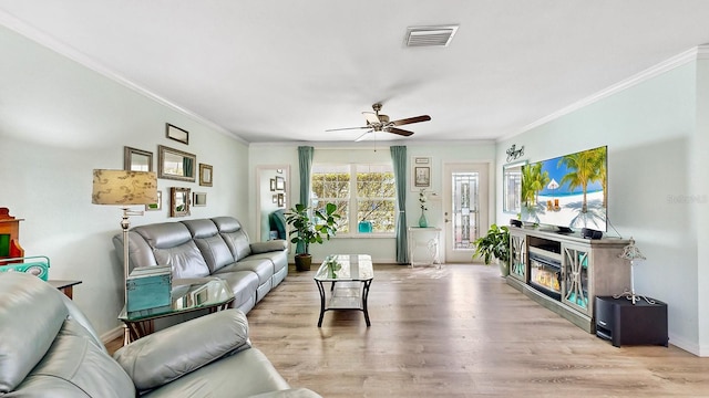 living room with ceiling fan, light hardwood / wood-style floors, and ornamental molding