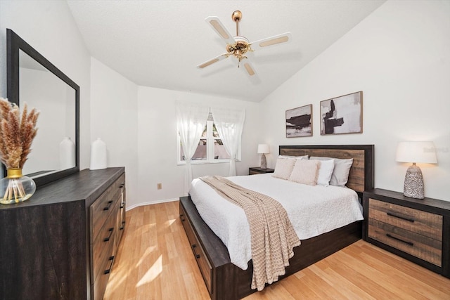 bedroom featuring ceiling fan, vaulted ceiling, and light wood-type flooring