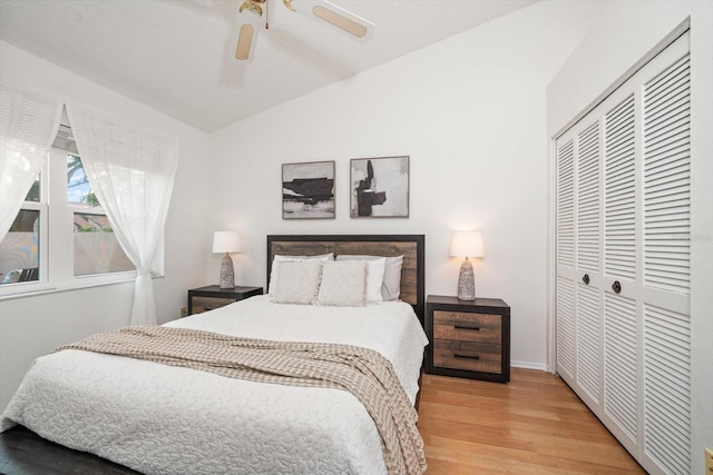 bedroom with ceiling fan, vaulted ceiling, wood-type flooring, and a closet