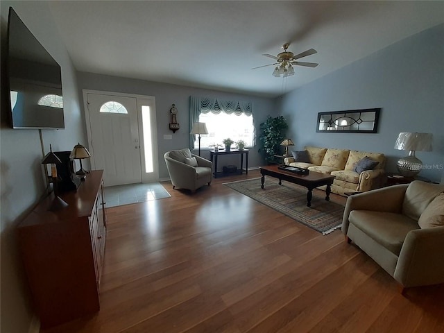 living room with ceiling fan, wood-type flooring, and vaulted ceiling