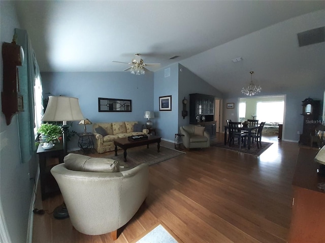 living room with dark hardwood / wood-style flooring, ceiling fan with notable chandelier, and vaulted ceiling