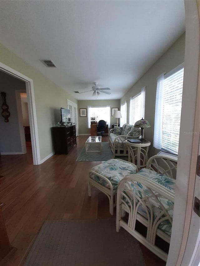 living room with ceiling fan and dark wood-type flooring