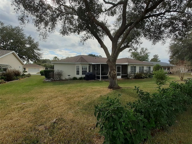 rear view of property with a sunroom and a lawn