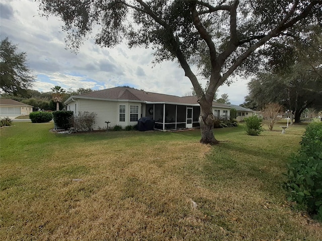 back of property with a sunroom and a lawn