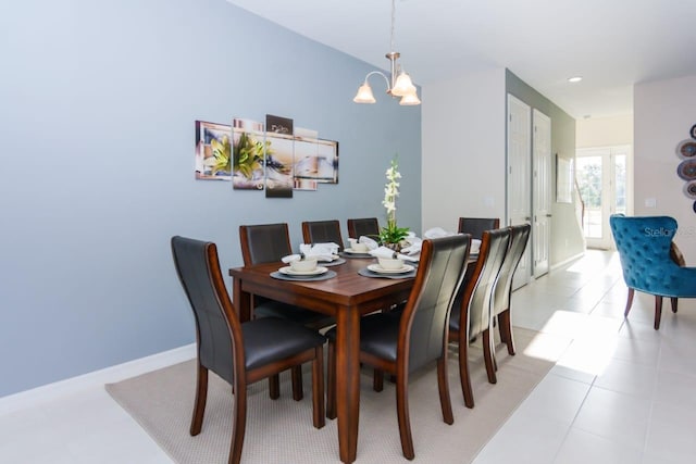 tiled dining room with a chandelier