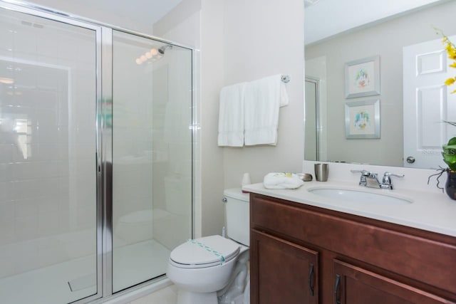 bathroom with vanity, toilet, and a shower with shower door