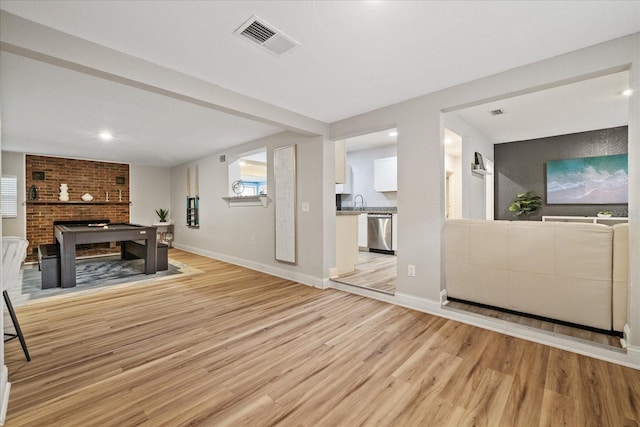 living room with a fireplace, light hardwood / wood-style flooring, and sink