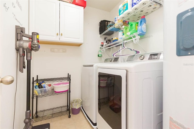 laundry area with cabinets, light tile patterned floors, and washer and clothes dryer