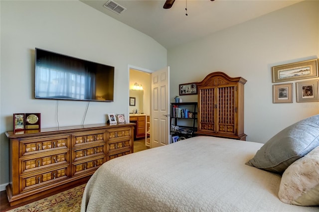 bedroom featuring wood-type flooring, connected bathroom, vaulted ceiling, and ceiling fan