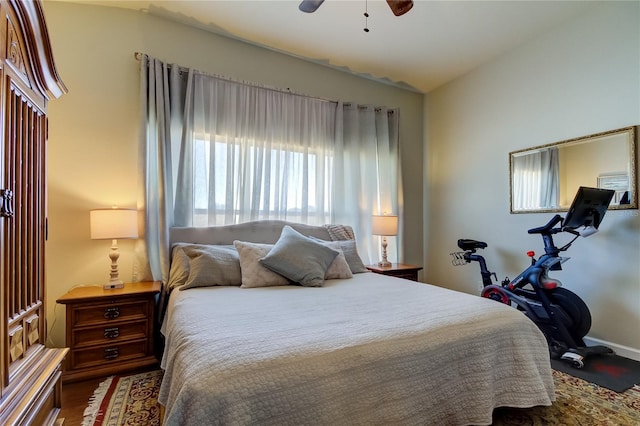 bedroom with ceiling fan, wood-type flooring, and vaulted ceiling