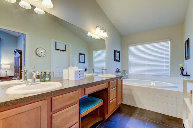 bathroom with vanity, tile patterned floors, lofted ceiling, and tiled tub