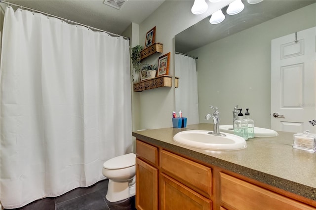 bathroom with tile patterned flooring, vanity, and toilet