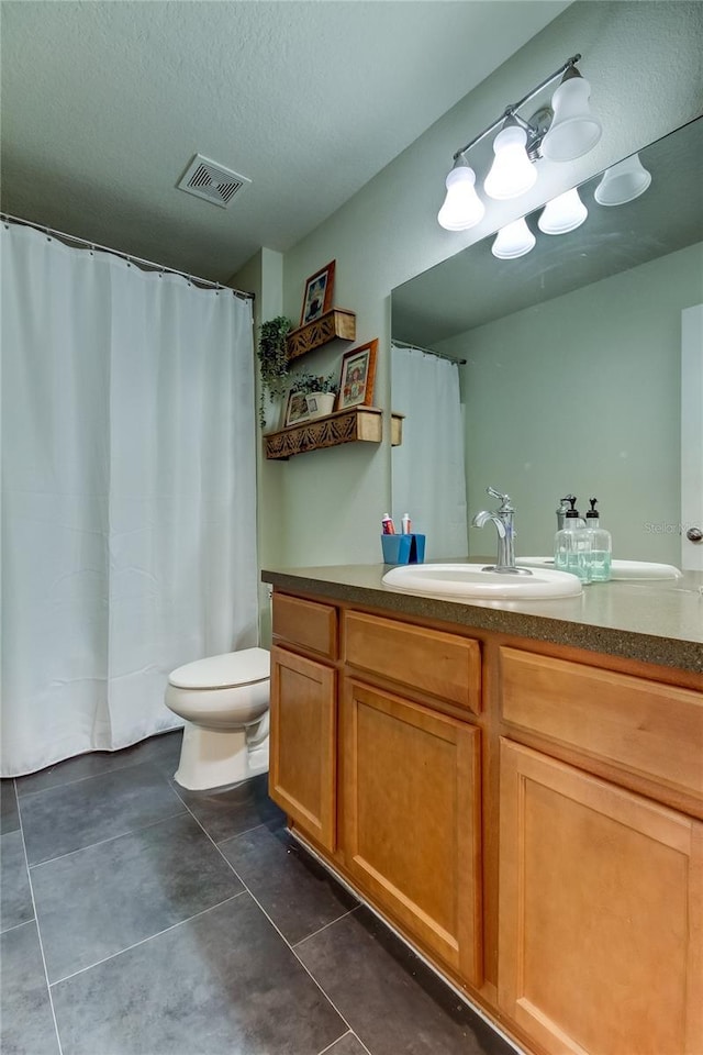 bathroom with vanity, a textured ceiling, and toilet