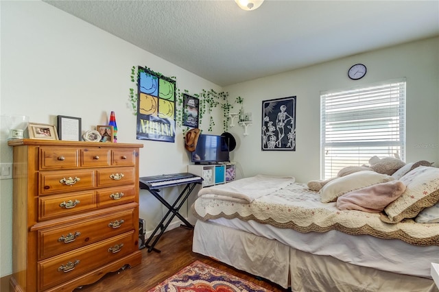 bedroom with a textured ceiling and dark hardwood / wood-style floors