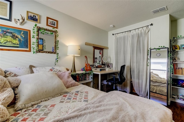 bedroom with hardwood / wood-style floors and a textured ceiling